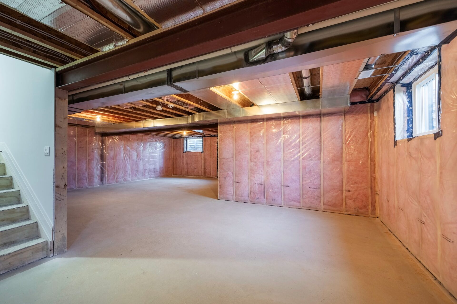 Unfinished basement showing the framing, poured floor and stair run