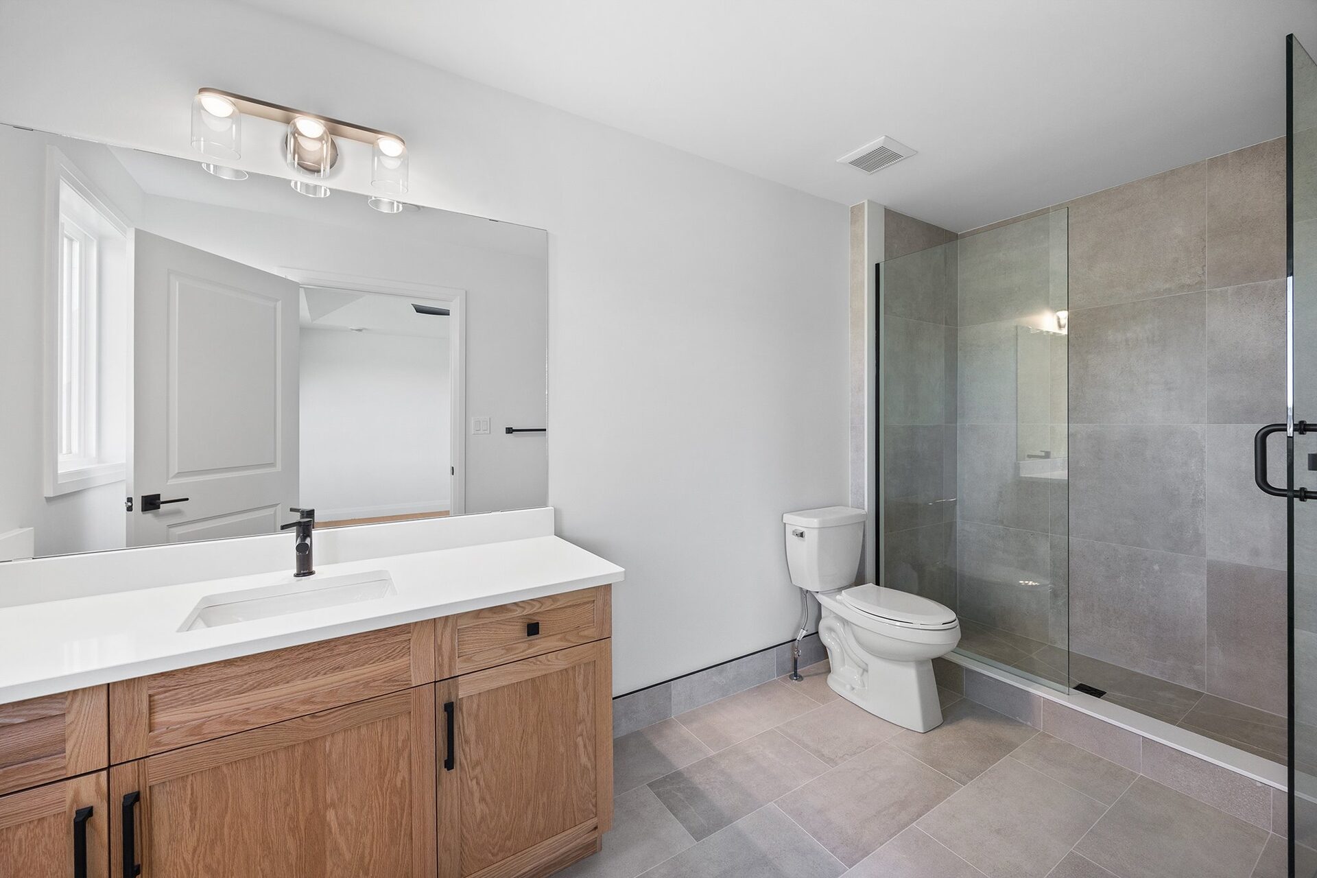 Main bathroom with a glass shower enclosure and a wood vanity