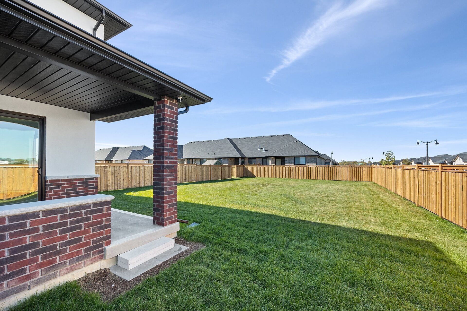 Covered rear porch of an Erie Isle home looking over the lawn