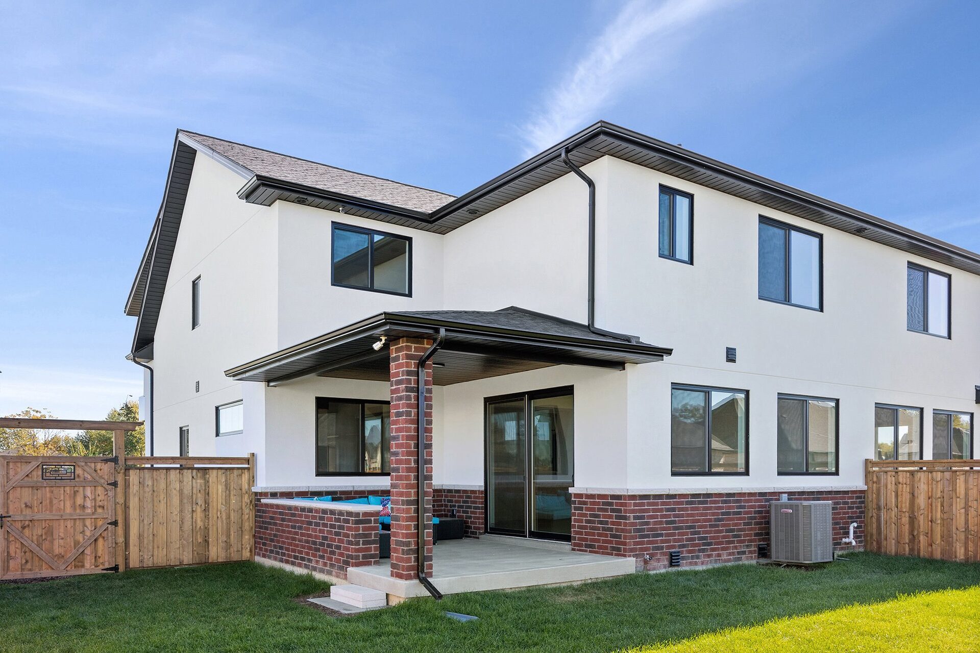 Rear elevation of an Erie Isle home, white stucco above a red brick base