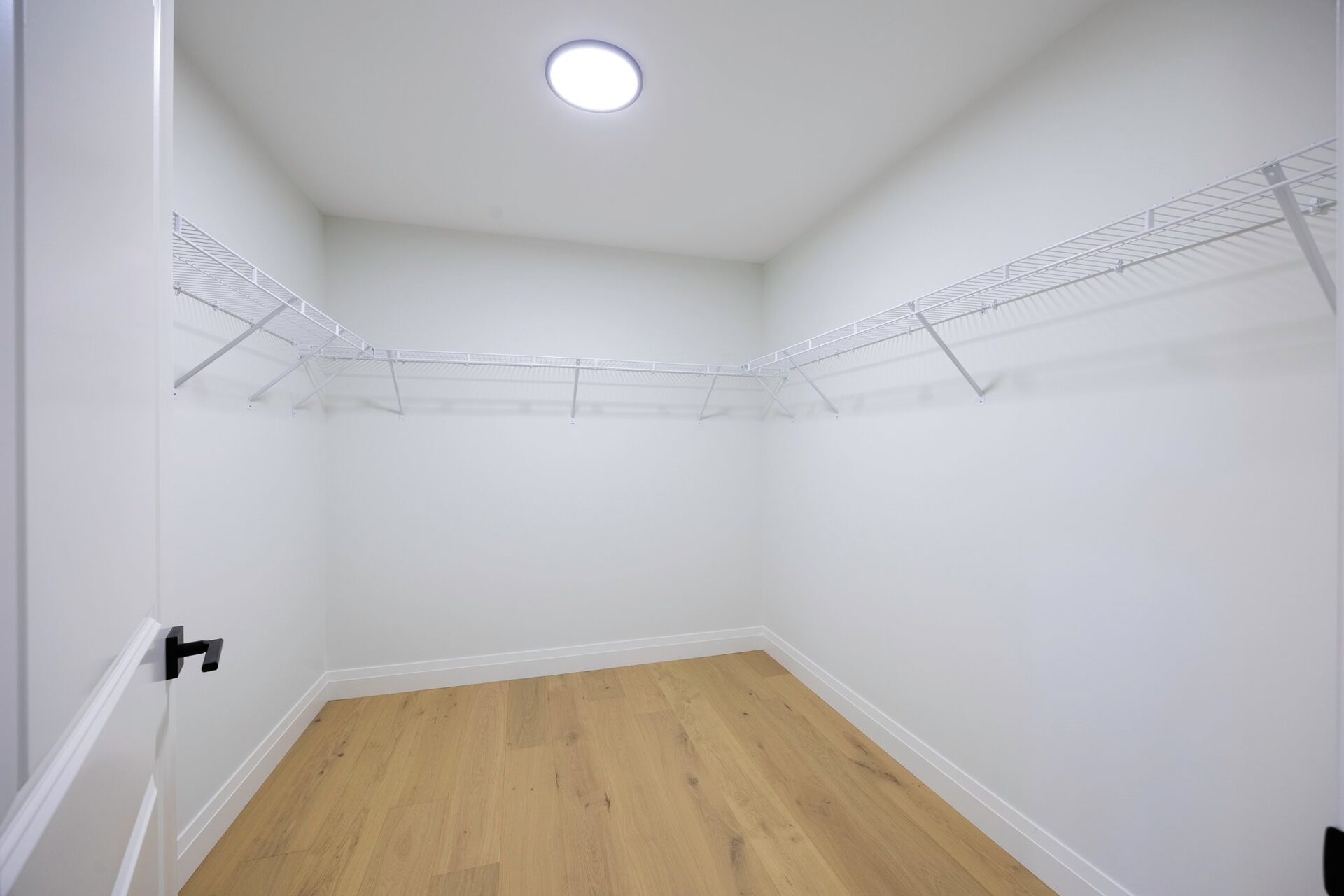 Walk-in closet fitted with wire shelving and hanging rails
