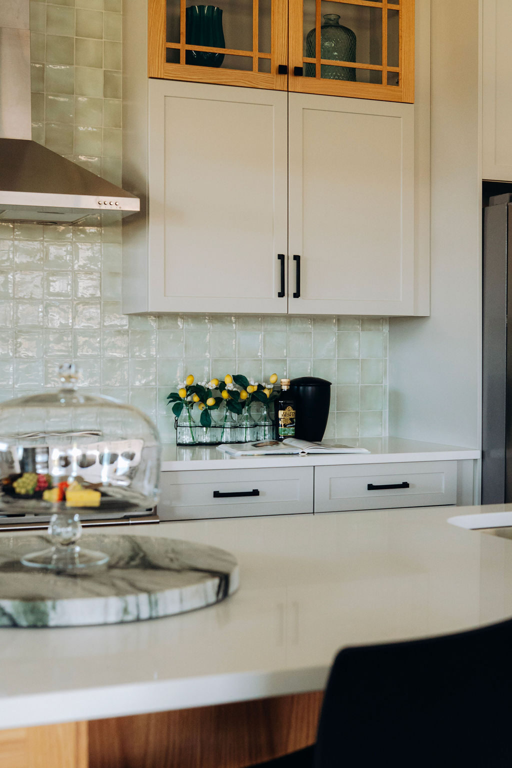 A glass cloche and marble serving tray on the quartz island counter