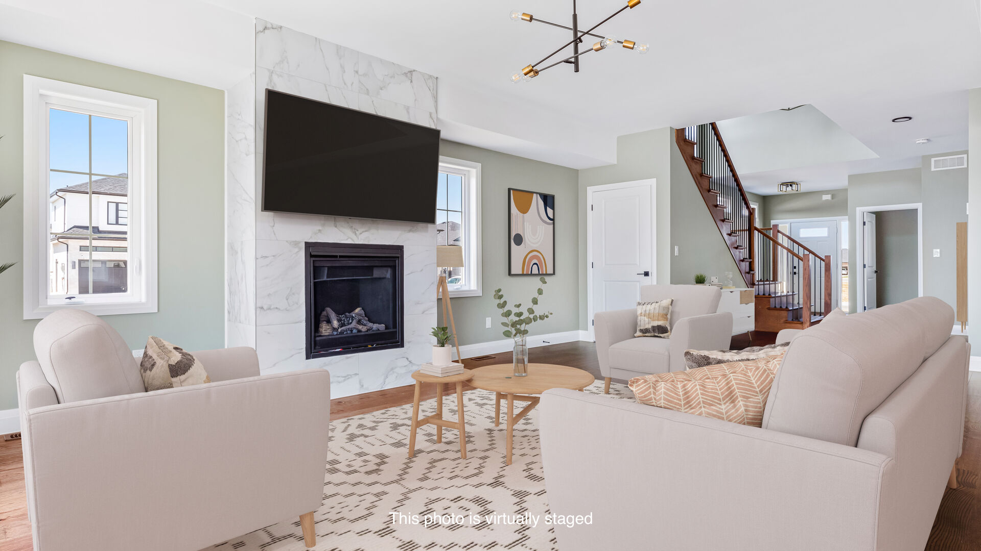 Virtually staged living room with a marble fireplace in a Landings of Kingsbridge townhome