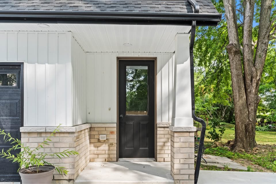 Front entry of the carriage house, with a black door under a covered porch